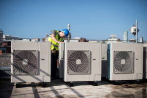 Commercial HVAC technician servicing rooftop units at a business.