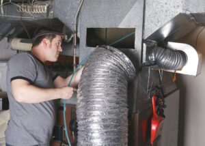 Technician-working-on-furnace-ductwork